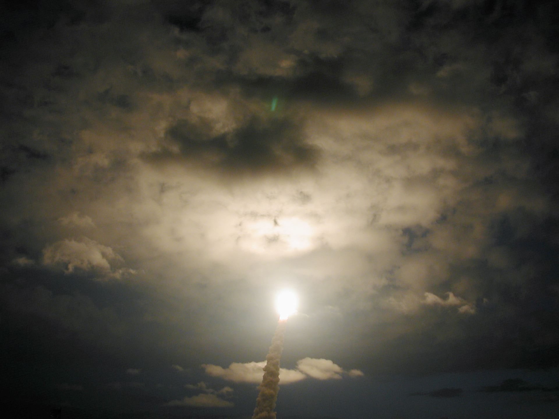 SM3B – Space Shuttle Colombia passes through a clearing in the clouds